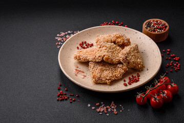 Delicious fresh crispy chicken nuggets on a dark concrete background