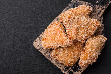 Delicious fresh crispy chicken nuggets on a dark concrete background
