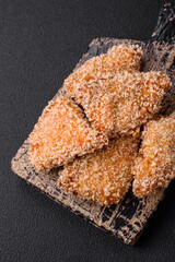 Delicious fresh crispy chicken nuggets on a dark concrete background