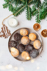 Haugemachte Muffins auf einem Teller, Tannenzweige und eine Lichterkette. Weihnachten, Draufsicht,...