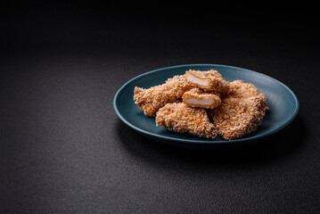Delicious fresh crispy chicken nuggets on a dark concrete background