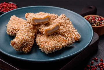 Delicious fresh crispy chicken nuggets on a dark concrete background