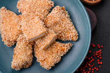Delicious fresh crispy chicken nuggets on a dark concrete background
