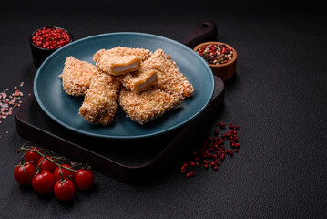 Delicious fresh crispy chicken nuggets on a dark concrete background