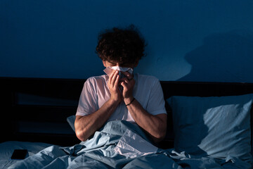 Muslim man suffering cold and flu trying to sleep. Young sick ill arabic guy with runny nose in...