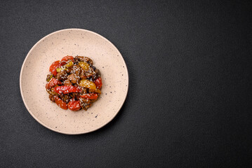 Warm salad with veal, tomatoes, peppers, zucchini, sesame, salt, spices and herbs