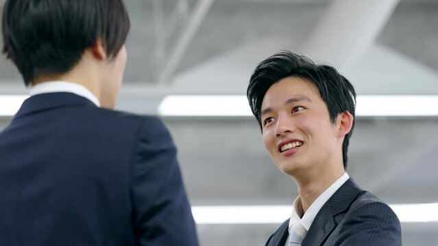 生意気な態度で同僚と話す若いビジネスマン