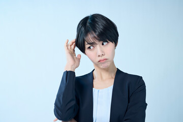 考え事をするショートヘアの女性会社員