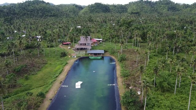 Wakeboarding Lake in Cable wake park of Siargao amid hills of tropical palm forest