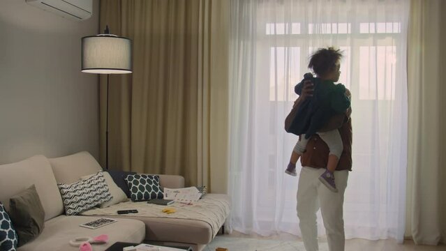 Little girl with curly hair running to her happy-looking father, then he lifting her up and rocking back and forth