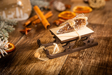 Christmas sleigh with a Christmas tree in the main plan and cinnamon and dried orange in the...