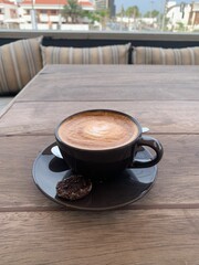 A freshly prepared cup of cortado coffee served on an outdoor terrace