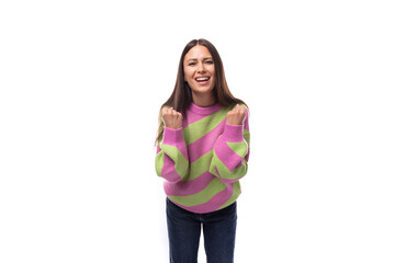 beautiful joyful young brunette woman in a striped pink sweater on a white background with copy space