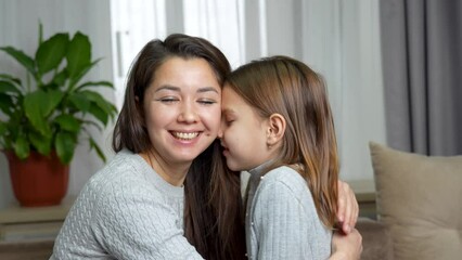Happy young mother and cute daughter playing together touching nose