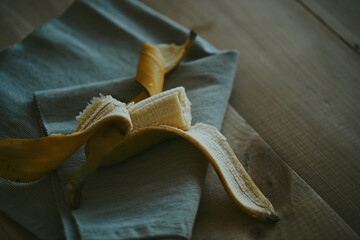 Fototapeta na wymiar Close-up of peeled sliced banana on wooden table background