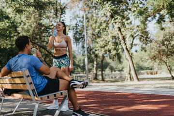 A fit caucasian couple exercising outdoors in a park. They practice professional sport, stretch, warm up their muscles and are highly motivated to maintain their healthy lifestyle.