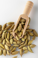 Cardamom seeds lie in a wooden scoop..Cardamom seeds used for making desserts and dishes. Cooking spice.