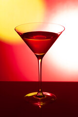 Glass martini glass on a red background..Wine glass with a drink on a red background.