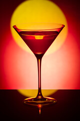 Glass martini glass on a red background..Wine glass with a drink on a red background.