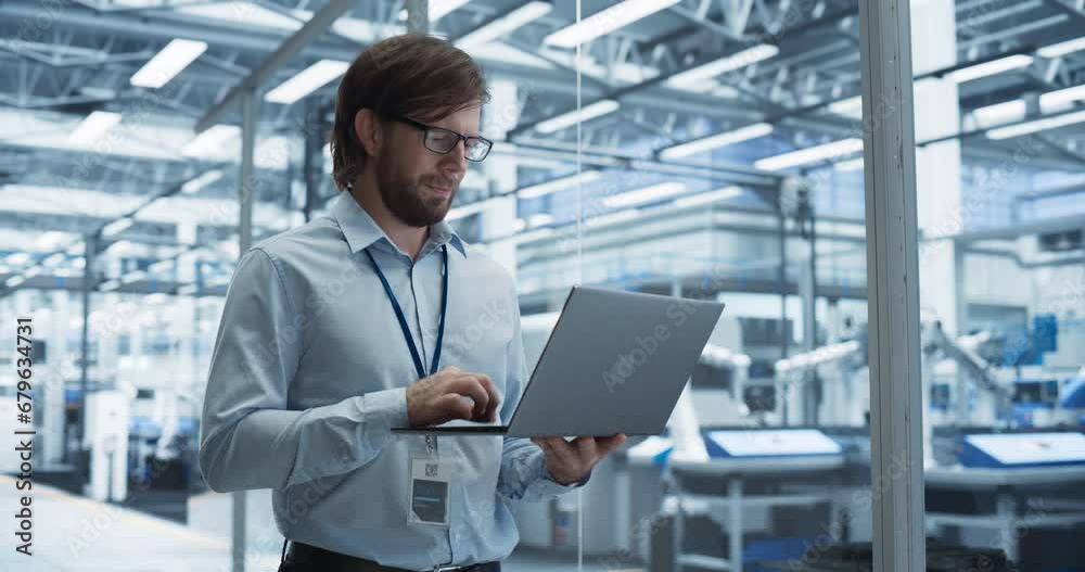 Aufkleber Portrait of a Handsome Engineer with Glasses Using Laptop Computer and Looking Around a Factory Facility with Equipment Producing Modern Electronic Components for Different Industries