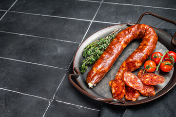 Sliced Chorizo sausage, slices of dry cured pork with herbs and spices. Black background. Top view. Copy space - obrazy, fototapety, plakaty