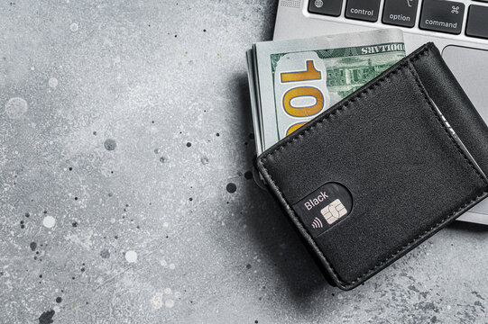 Workplace with stylish leather wallet with money, Laptop. Gray background. Top view. Copy space