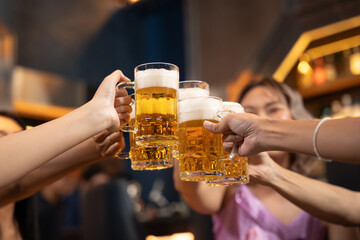 Close-up Group of People Holding Beer and Cheer in Restaurant. They Enjoying with Night Party...