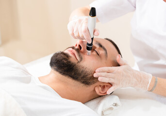 Male cosmetology. Dermastamp fractional mesotherapy treatment for man in cosmetology clinic.