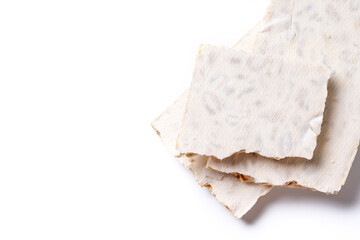 Traditional Christmas sweet, pieces of delicious almond nougat isolated on white background