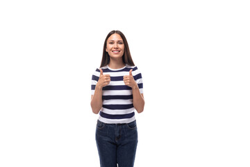A slender young brunette caucasian woman with light make-up dressed in a striped T-shirt and jeans shows class with her hands