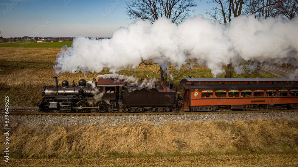 Wall mural Ronks, Pennsylvania, December 4, 2022 - Aerial Parallel View of a Restored Antique Steam Passenger Train Traveling Thru The Countryside on a Sunny Autumn Day - Wall murals