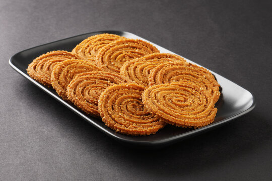 Crunchy fried homemade Chakli in a plate. Chakli is a savory snack from India made out of rice, mixed yellow and green lentils along with spices Diwali festival Indian snack called Chakli