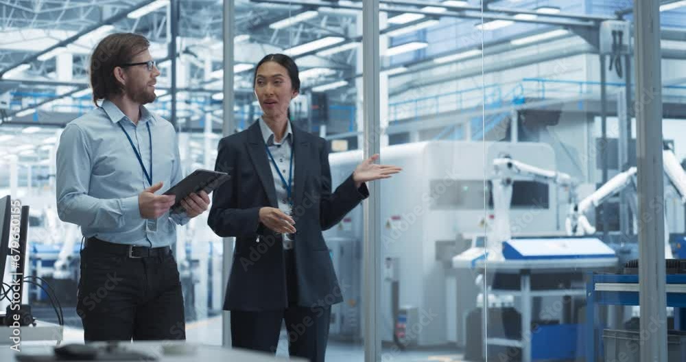 Poster Two Diverse Engineers Walking in Office, Using Tablet Computer at an Electronics Factory. Female and Male Specialists Chatting, Monitoring Robots on a Modern Assembly Line
