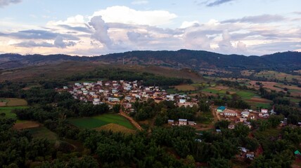 Fototapeta na wymiar Aerial view of a village in the mountain region of Myanmar surrounded by agriculture fields.