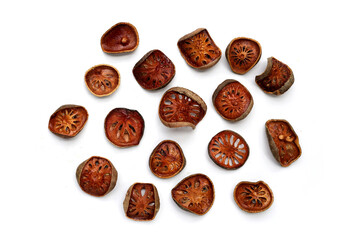 Dried bael fruit slices on white background.