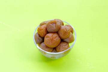 Pickled plums on green background.