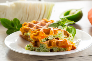 cooked two-color vegetable waffles made from cabbage and carrots. - obrazy, fototapety, plakaty