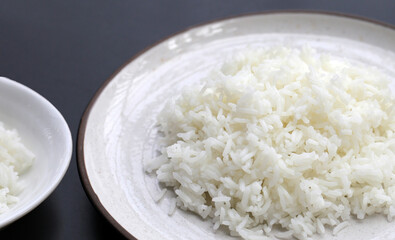Cooked rice in plate on dark background.
