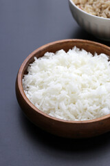 Cooked rice in bowl on dark background.
