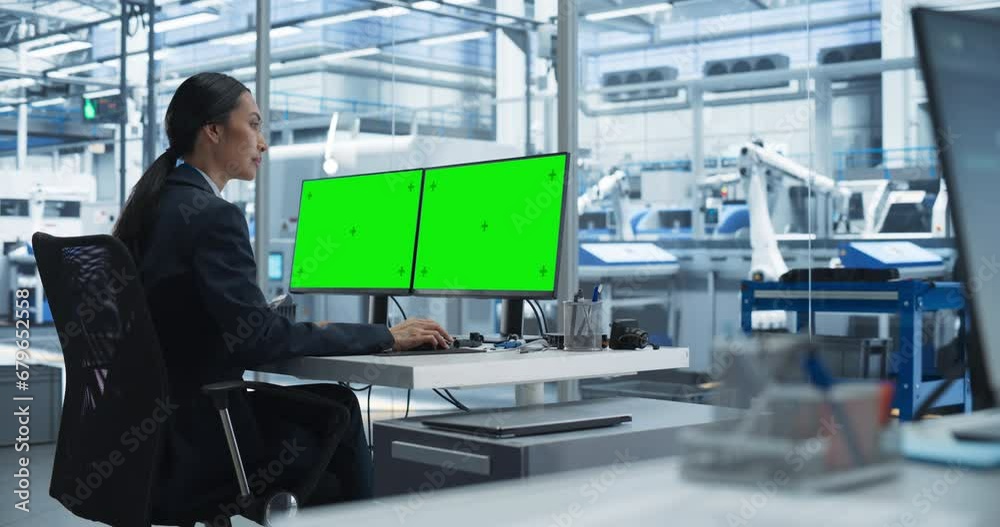 Aufkleber Female Robotics Technician Working on a Desktop Computer with Green Screen Chromakey Mock Up Display in a Factory Office. Technological Research and Development Facility with Autonomous Assembly Line