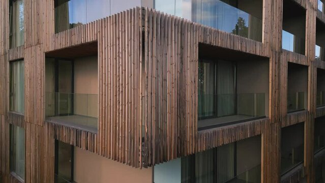 A drone flies along the facade of a modern hotel. Windows and balconies are visible