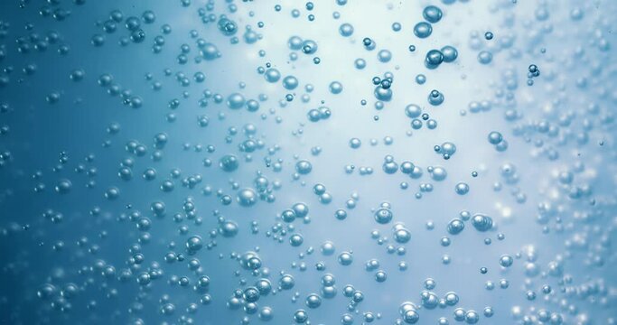 Many water bubbles in blue water close up, abstract water wave with bubbles in slow motion.