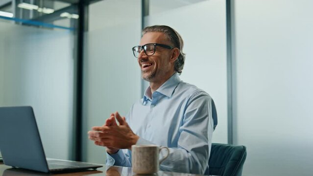 Glad man celebrating success at workplace close up. Joyful businessman rejoicing