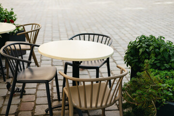 Outdoor street cafe tables ready for service. Empty cafe terrace with table and plastic chair, morning time. Food concept