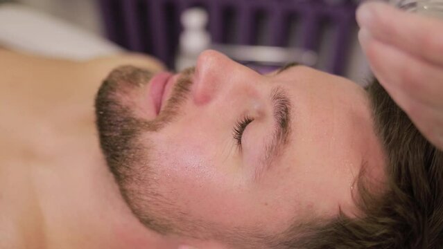 A handsome man undergoing a procedure at a beautician. Facial skin cleansing