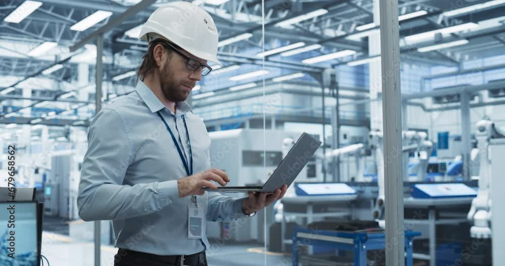 Leinwandbilder chief technology officer working on laptop at a conveyor at a factory with autonomous robotic arms. 