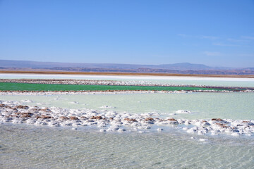 Laguna Tebenquiche, um lago de sal com cores vibrantes azul, verde e amarela ao lado do vulcão Licancabur.  