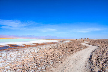 Laguna Tebenquiche, um lago de sal com cores azul, verde e amarela ao lado do vulcão Licancabur. 