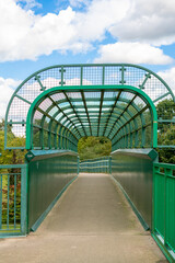 Metal walkway bridge above railway tracks in the middle of the forest in England