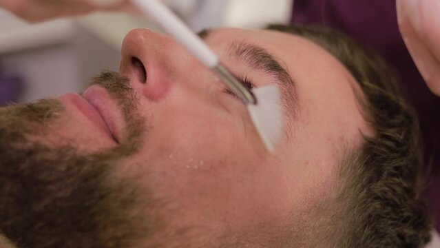 A man undergoes an anti-aging facial skin treatment at a health center. A guy in a beauty salon. Modern spa salon